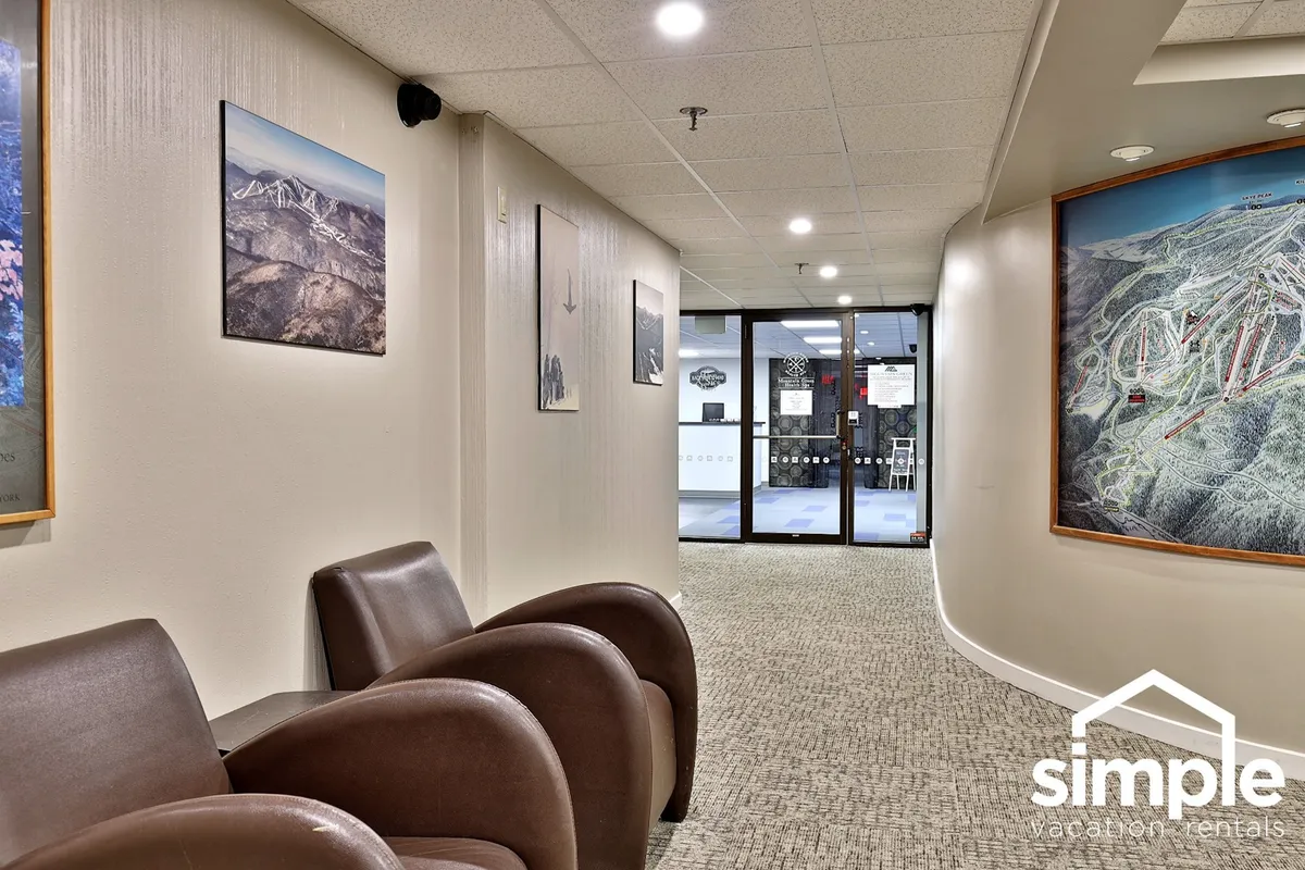 This image features a comfortable seating area with inviting furniture, photographic art on the walls, and a large window that offers a view of the outdoors, connecting the interior to the exterior environment.