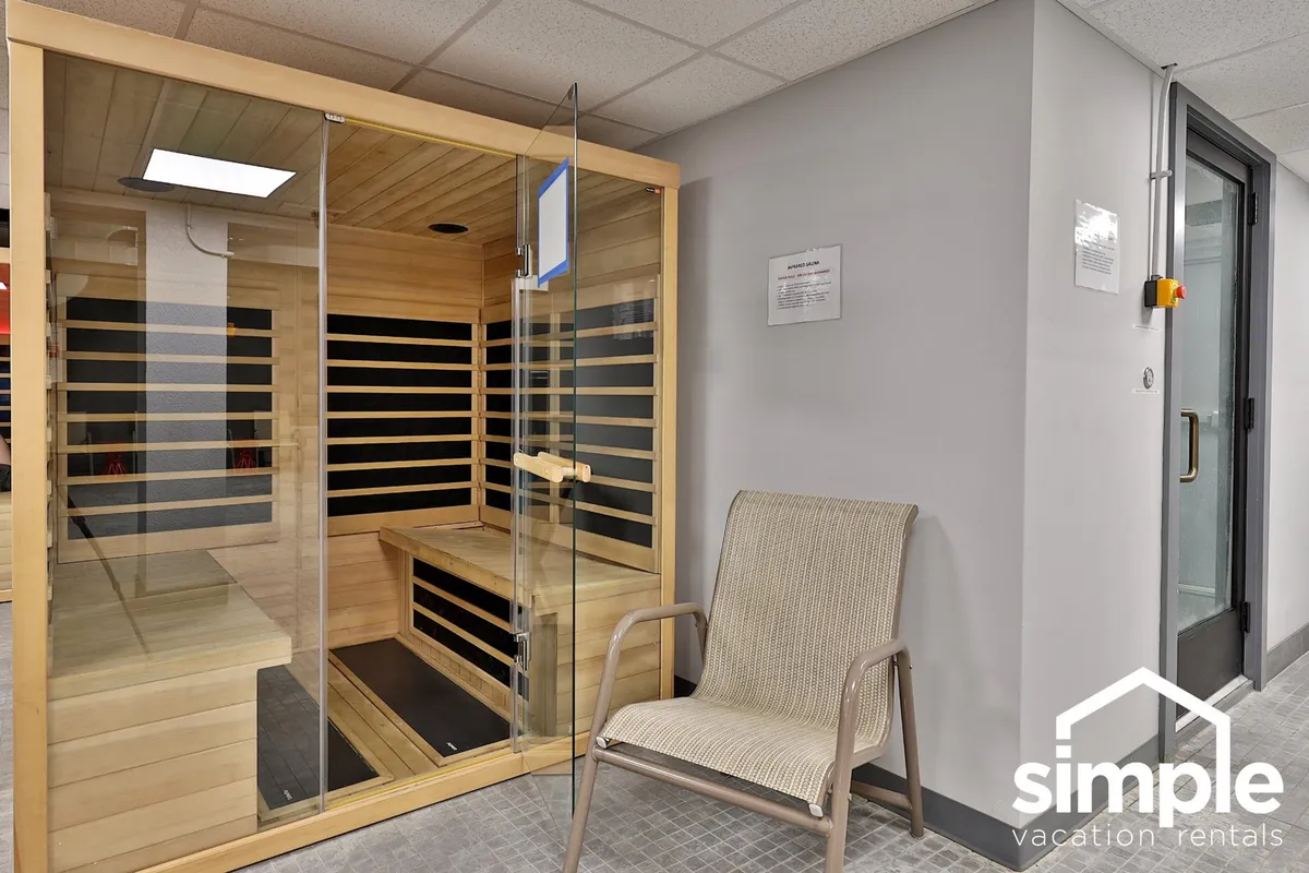 A cozy sauna interior with a wooden bench and a single chair, exuding a sense of relaxation and wellness. The tranquil ambiance is ideal for guests seeking a soothing escape within the resort facilities.